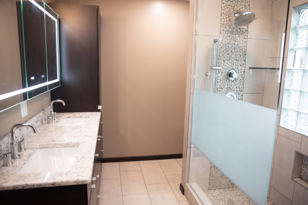 Bathroom remodel with walk-in shower, granite vanity, and neutral wall tones