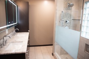 Bathroom remodel with walk-in shower, granite vanity, and neutral wall tones