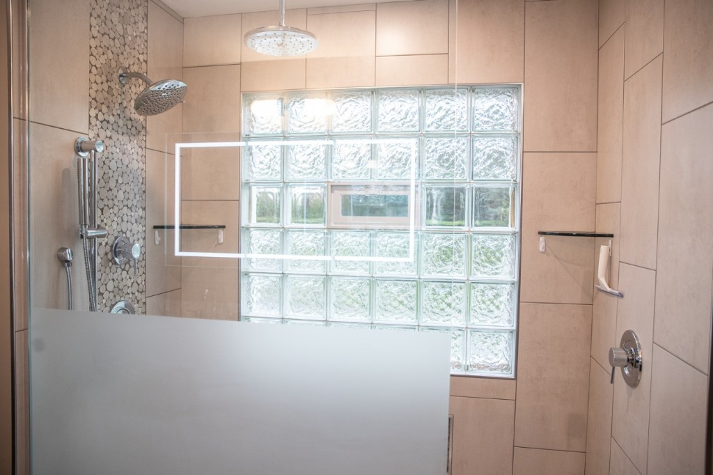Spacious bathroom with granite vanity, mirror, and dark cabinetry