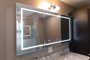 Modern bathroom with illuminated LED mirror and granite countertop