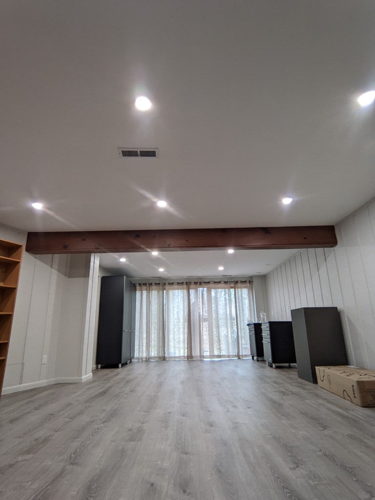 Finished basement remodel in Akron with recessed lighting and wood beam ceiling detail