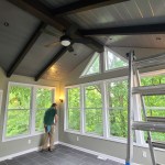 Contractor completing windows and wall finish in a custom sunroom