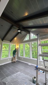 Contractor completing windows and wall finish in a custom sunroom