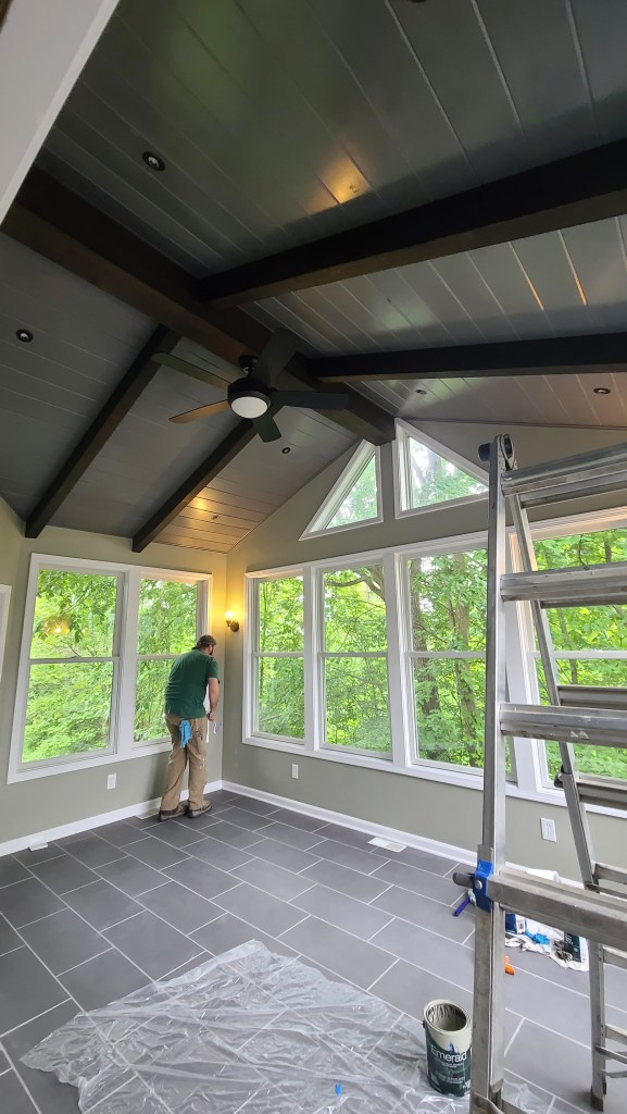 Contractor completing windows and wall finish in a custom sunroom