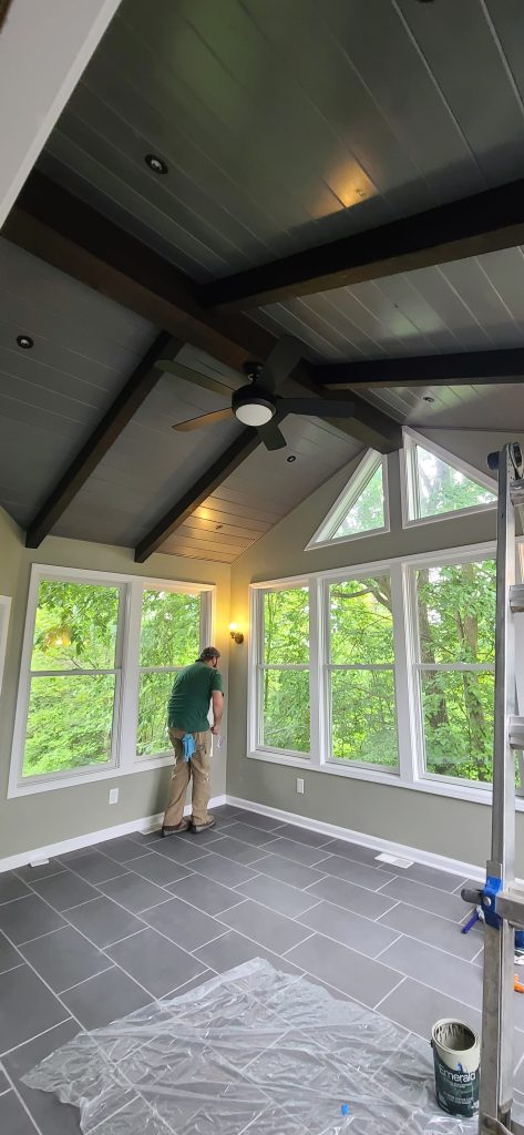 Contractor completing windows and wall finish in a custom sunroom