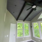 Unfurnished sunroom with vaulted ceiling, fan, and large windows