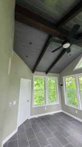 Unfurnished sunroom with vaulted ceiling, fan, and large windows
