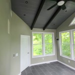 Sunroom with natural tile flooring and large windows for scenic views