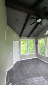 Sunroom with natural tile flooring and large windows for scenic views