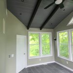 Sunroom with natural tile flooring and large windows for scenic views