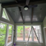 Bright four-season room with wood beam ceiling and scenic views