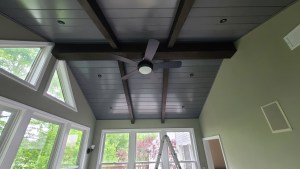 Ceiling fan and wood-beam ceiling in modern sunroom