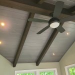 Close-up of vaulted sunroom ceiling with exposed beams, recessed lights, and ceiling fan