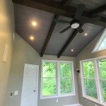 Ceiling fan installation in sunroom with recessed lighting and beam design