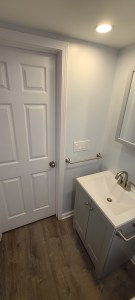 Simple white vanity and towel bar in clean bathroom renovation