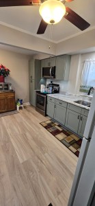 Spacious kitchen with green base cabinets and marble-style countertops
