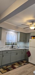 Kitchen with ceiling fan, updated countertops, and soft green cabinetry