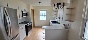 Galley-style kitchen remodel with stainless steel appliances and white cabinets by local kitchen remodel contractors