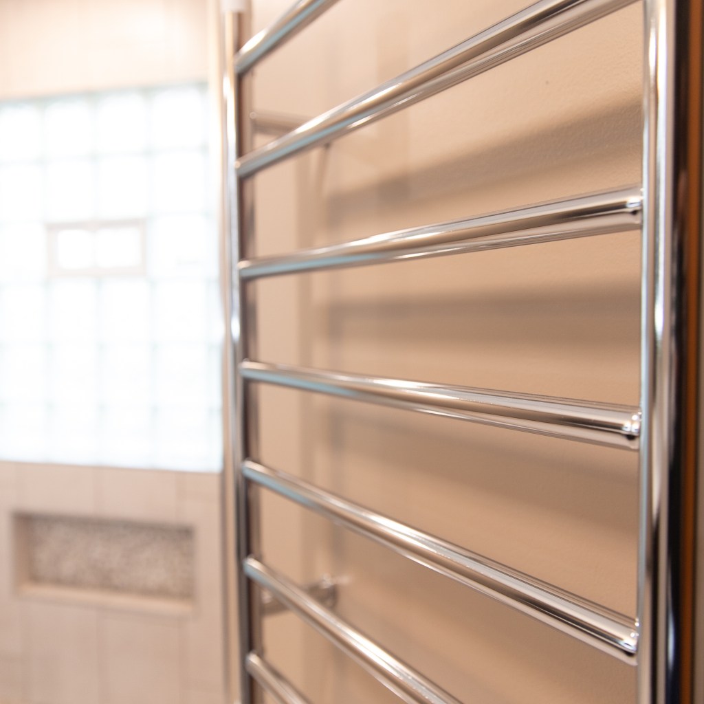 Chrome heated towel rack installed in modern bathroom remodel by a local general contractor.