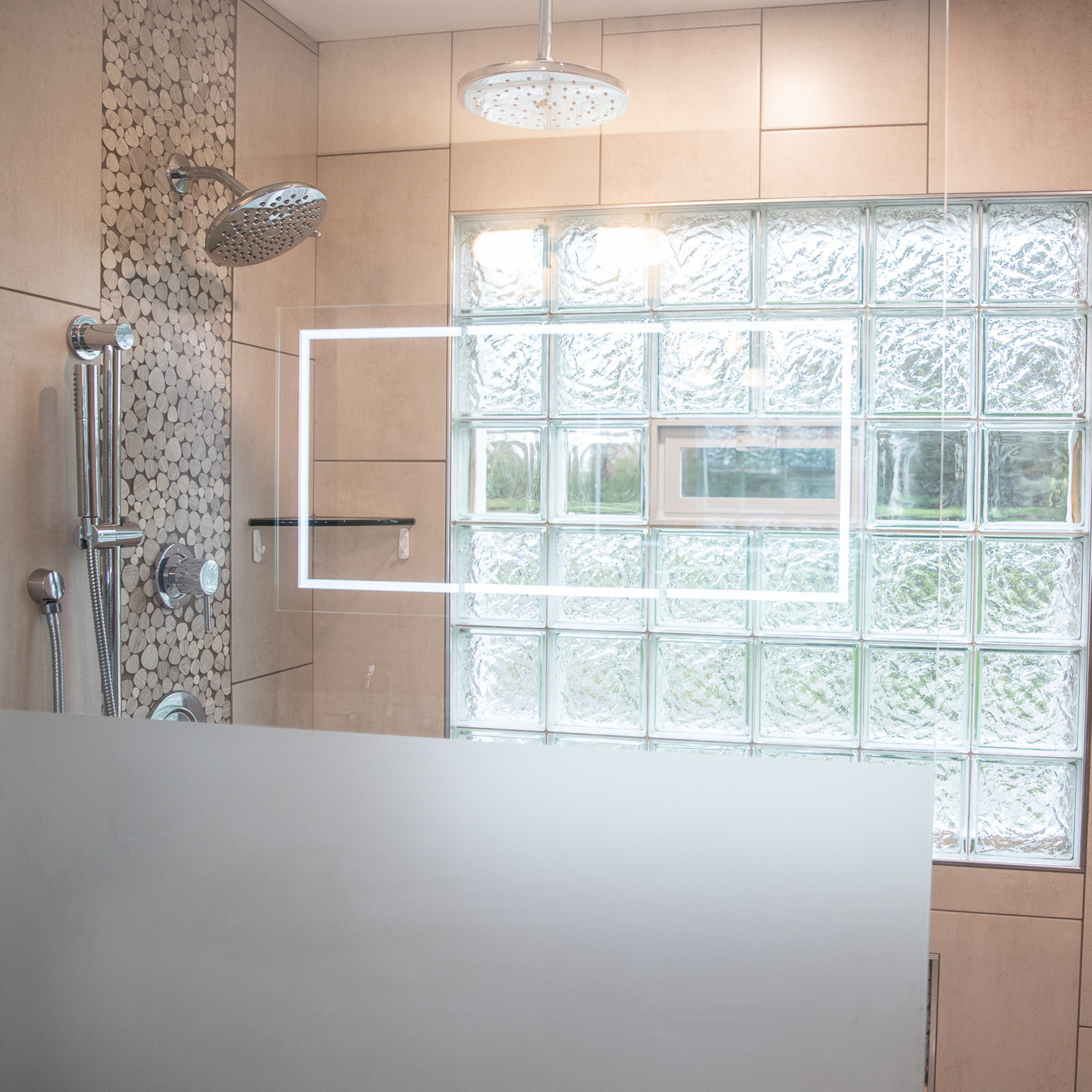 Custom walk-in shower with pebble tile accent wall, rainfall showerhead, glass block window, and frameless glass enclosure.