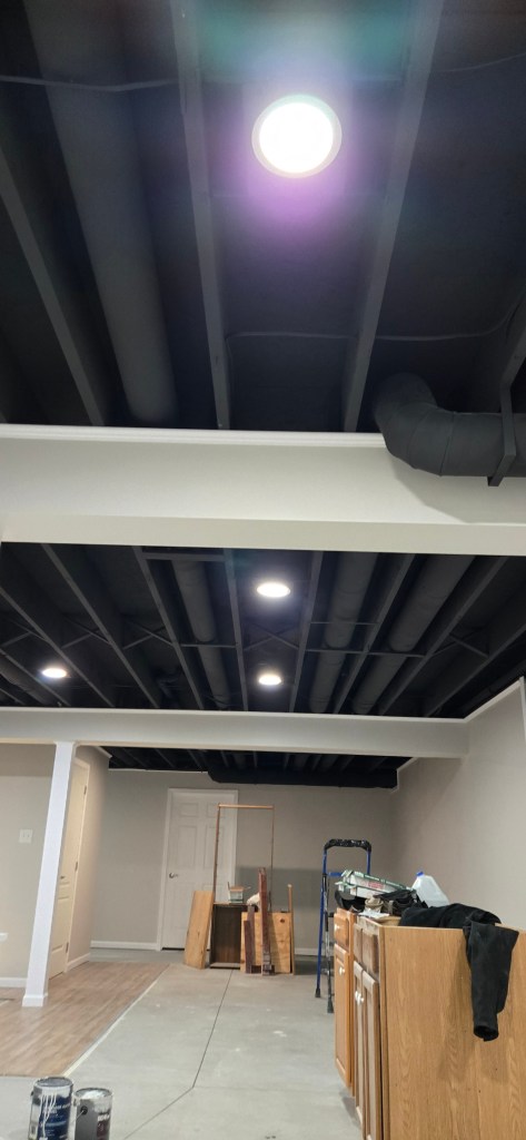 Finished basement hallway in Akron, Ohio with painted open ceiling, recessed lighting, new doors, and clean trim work.