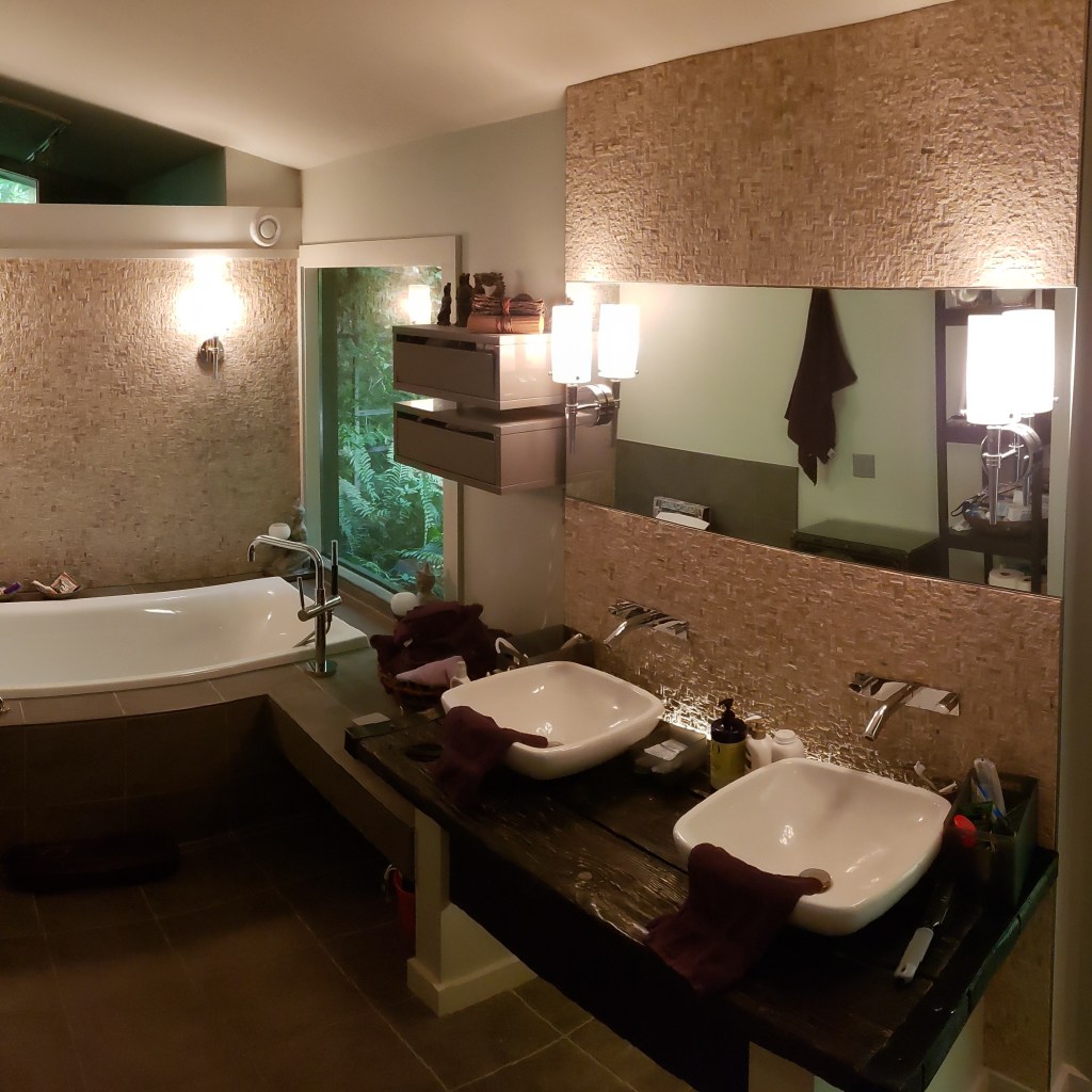 Custom double vanity with vessel sinks and freestanding tub in a modern spa bathroom