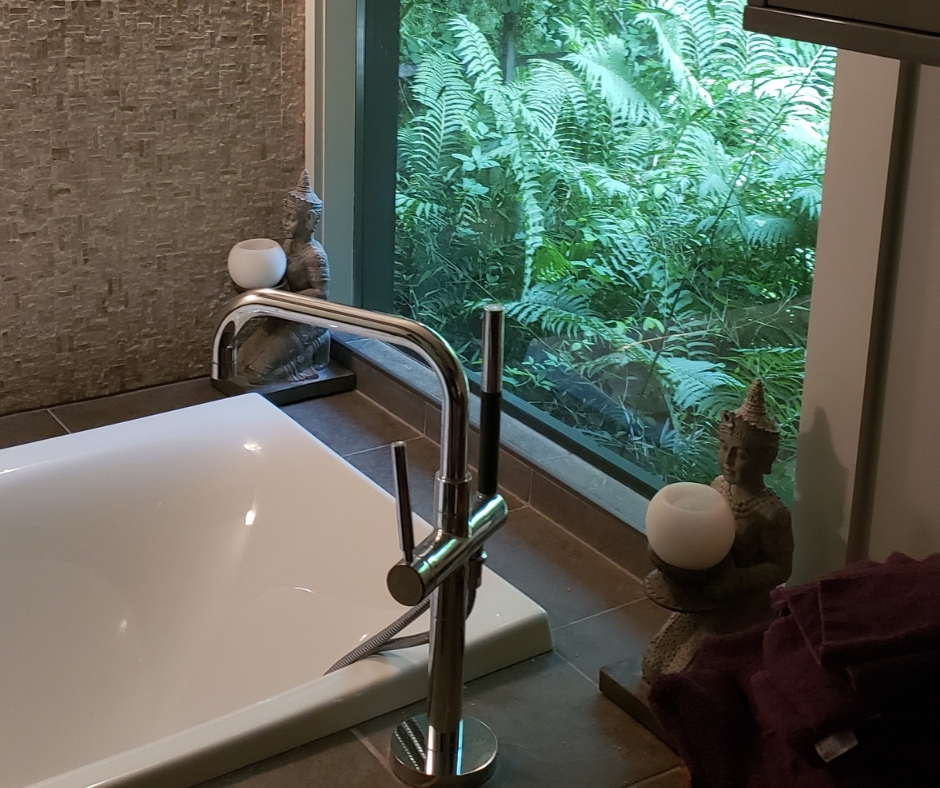 Modern bathroom remodel with freestanding tub, large window, and luxury fixtures