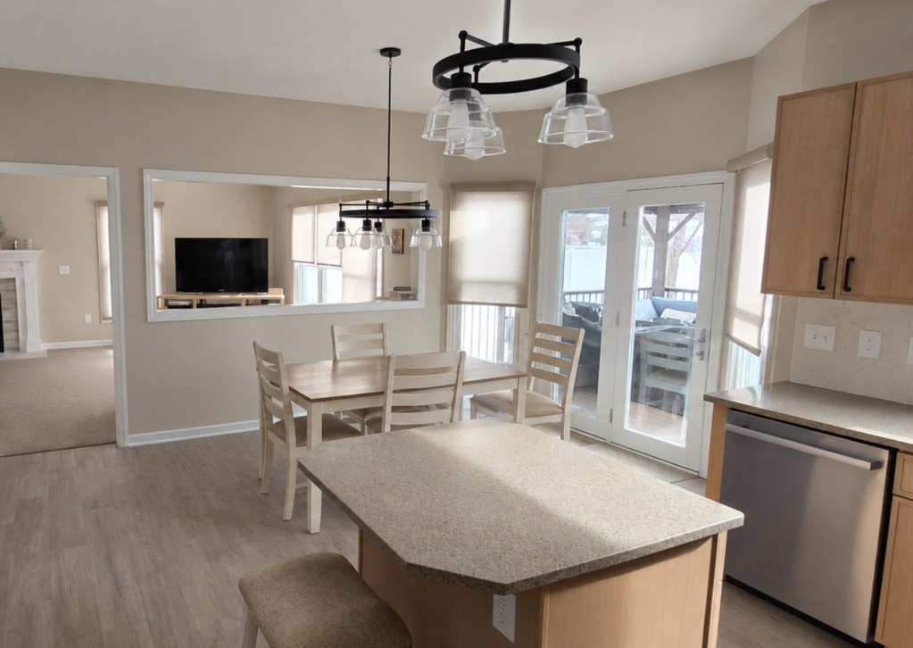 Open concept kitchen remodeling in Akron OH with custom wood cabinets, quartz countertops, oversized island, stainless steel appliances, and modern lighting.