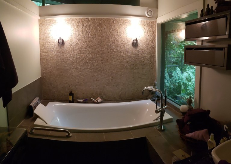 Modern bathroom remodel in Akron OH featuring freestanding bathtub, custom tile wall, modern lighting, and spa-inspired bathroom design.