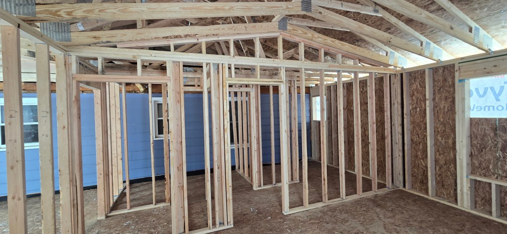 Interior framing for a home addition in North Royalton, Ohio featuring engineered roof trusses, framed walls, and new room layout during construction.