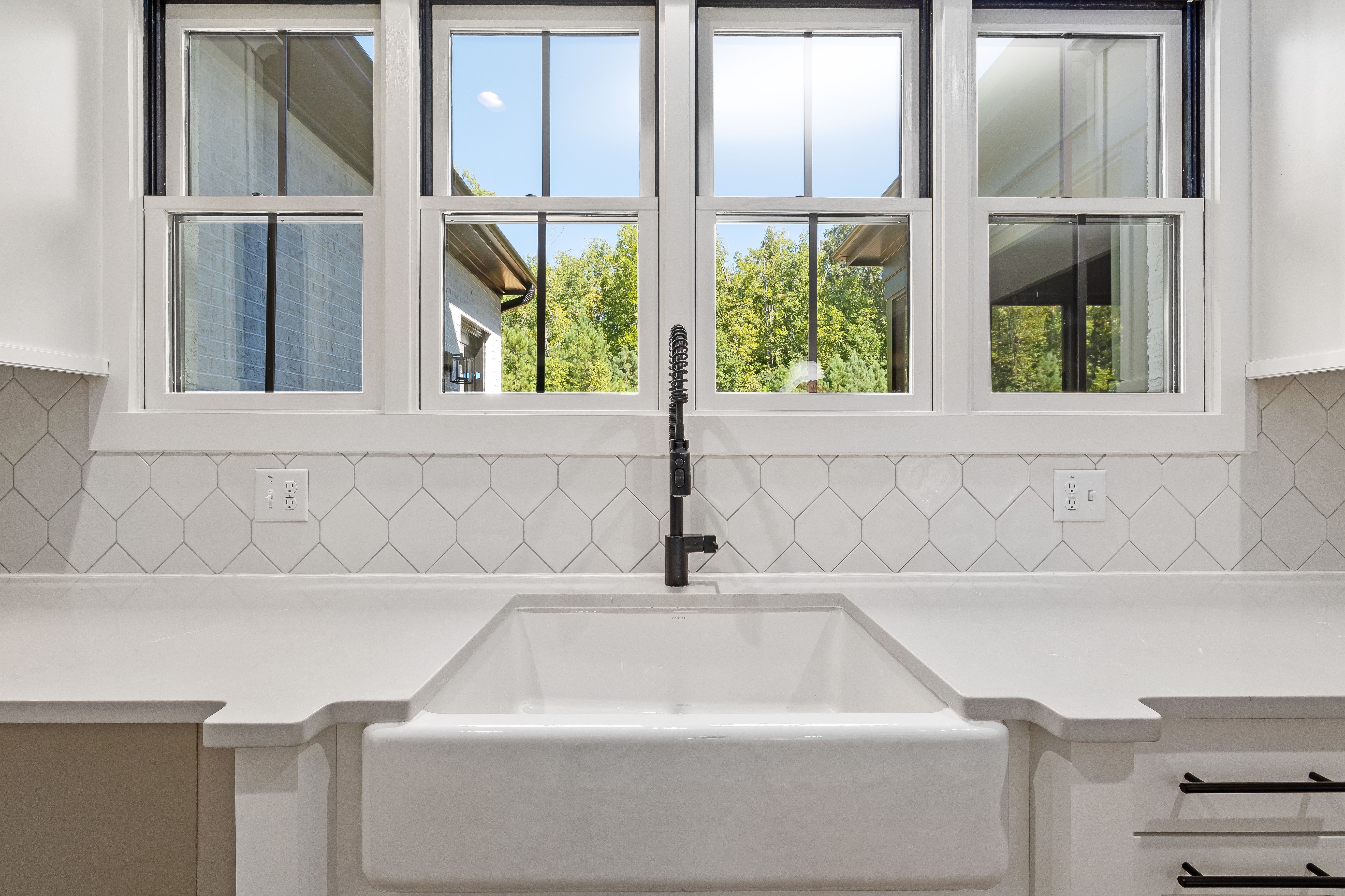 Bright kitchen interior featuring modern sink and large window with outdoor view.