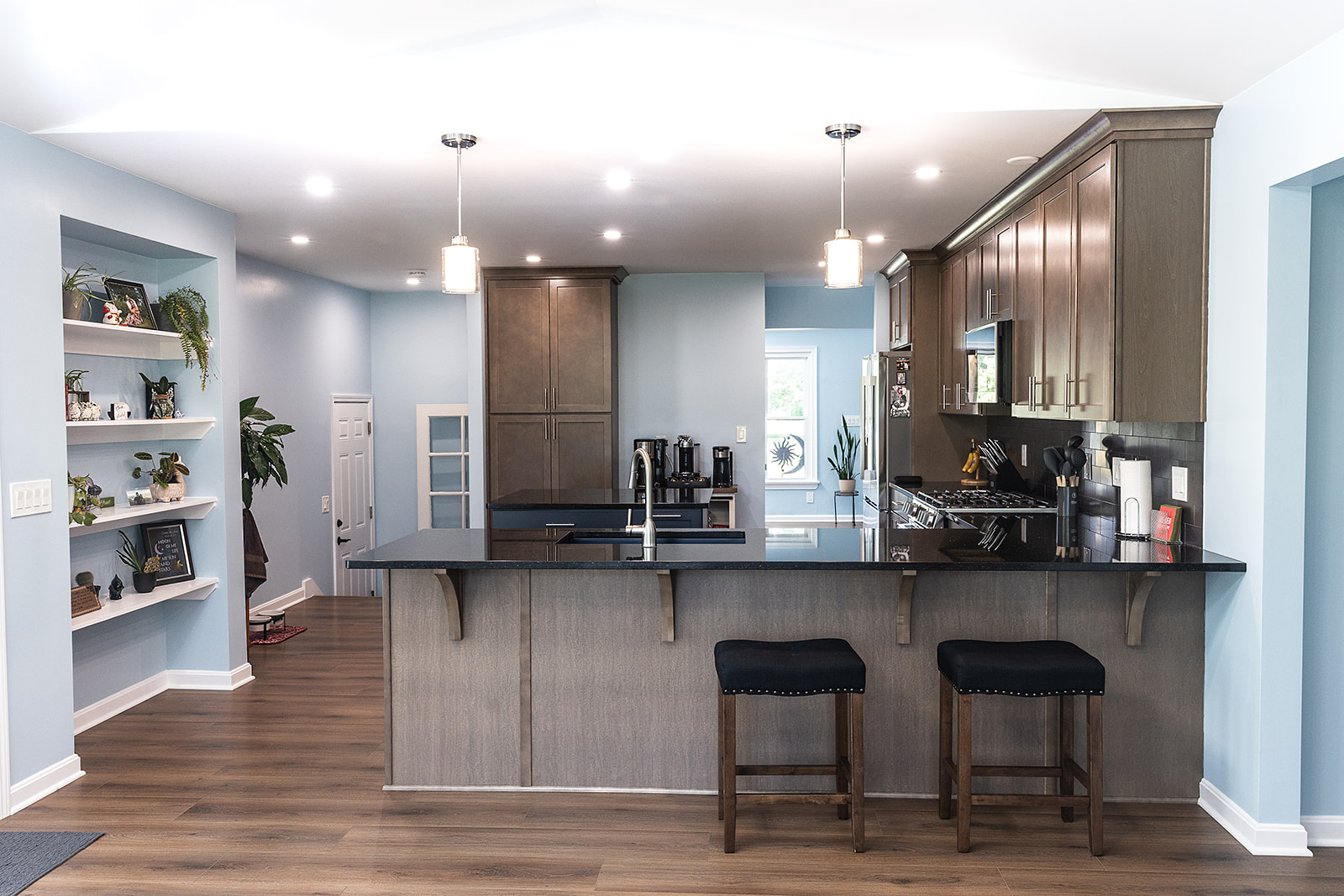 Finished kitchen remodel in North Royalton, Ohio with breakfast bar, custom cabinetry, black countertops and open floor plan.