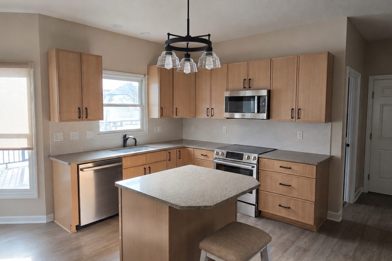 Modern kitchen renovation in Akron OH featuring custom cabinets, quartz countertops, stainless steel appliances, and large kitchen island.