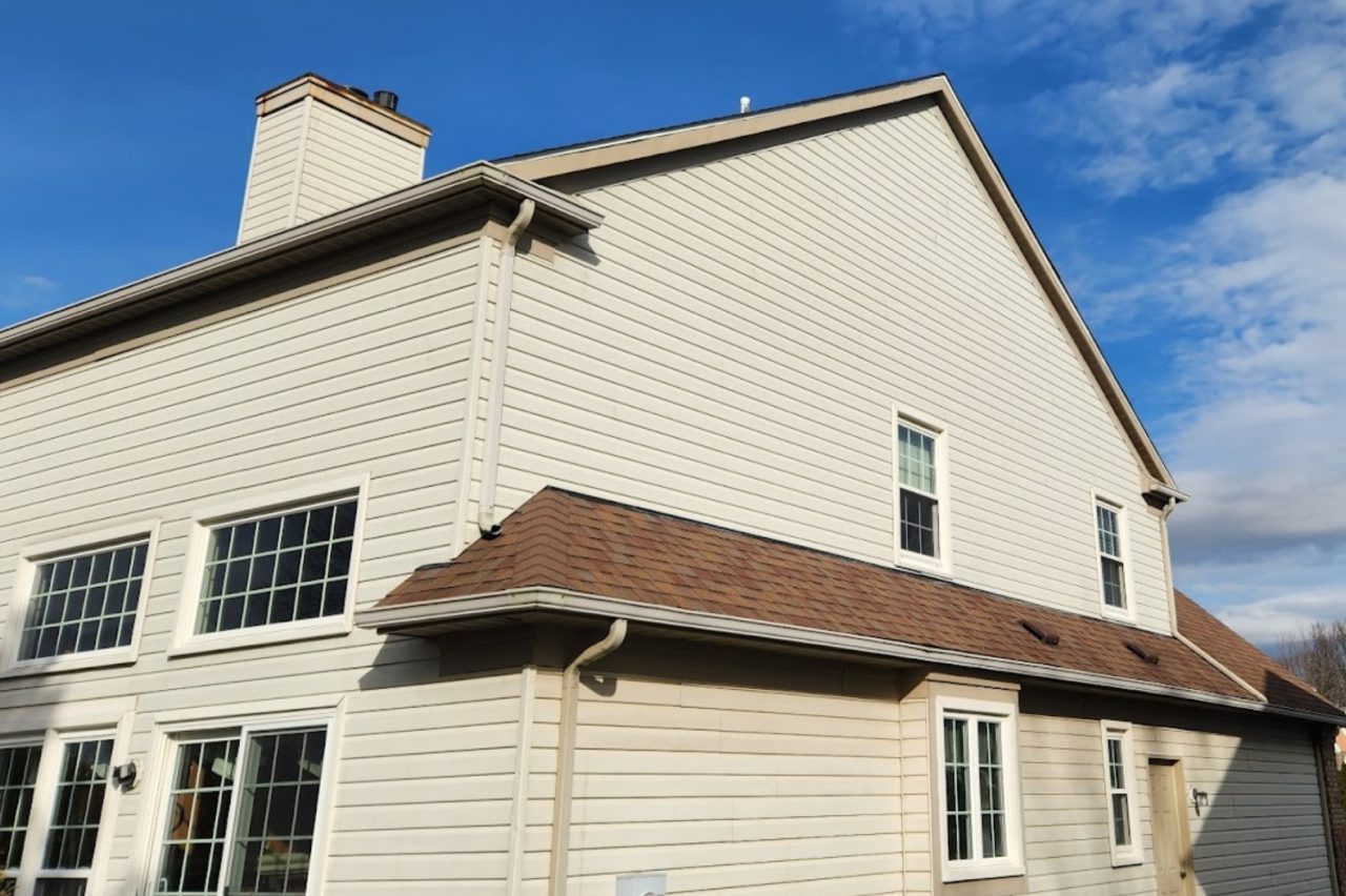 Exterior siding and window installation on Akron home with beige Hardie board