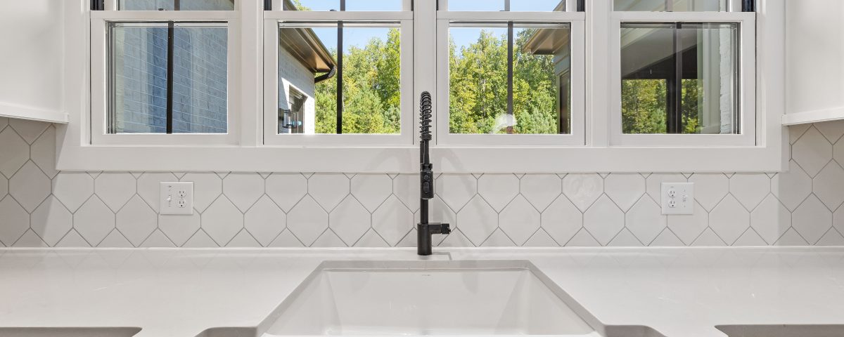 Bright kitchen interior featuring modern sink and large window with outdoor view.